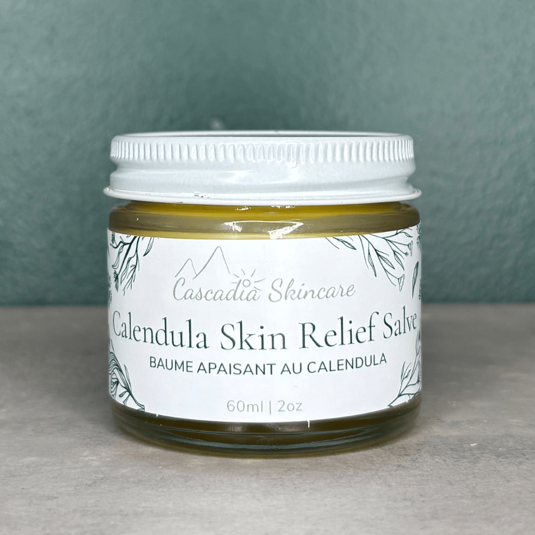 Calendula Skin Relief Salve on a grey countertop and green background