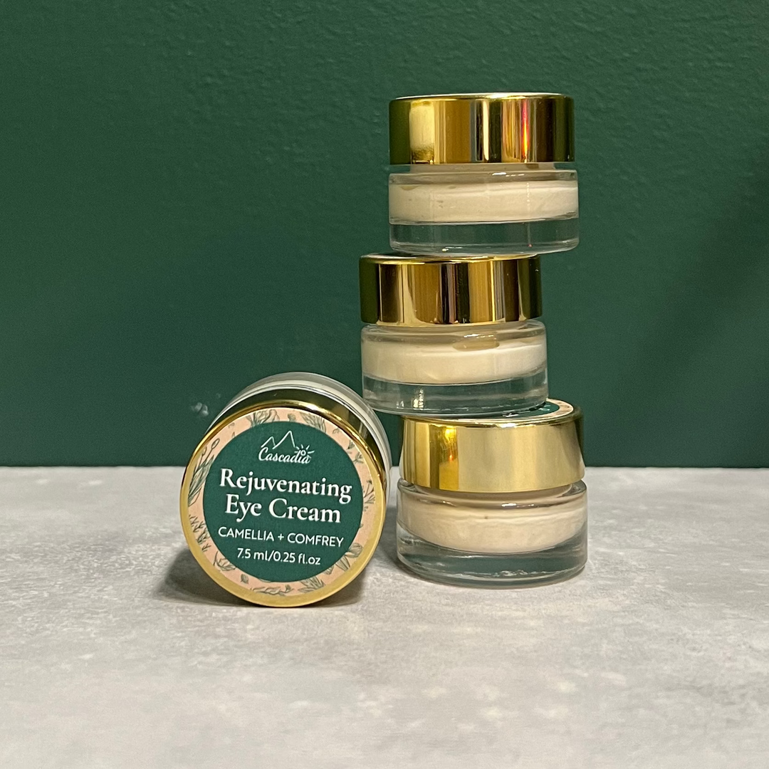 Jars of eye cream stacked beside another jar of Cascadia Skincare Botanical Eye Cream