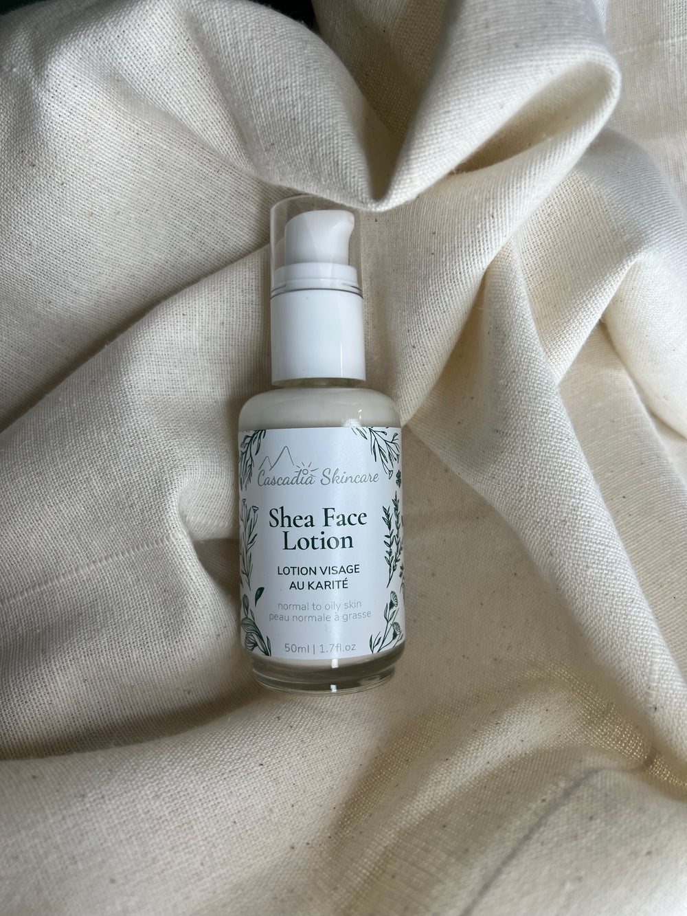 Shea face lotion bottle on a textured beige fabric background