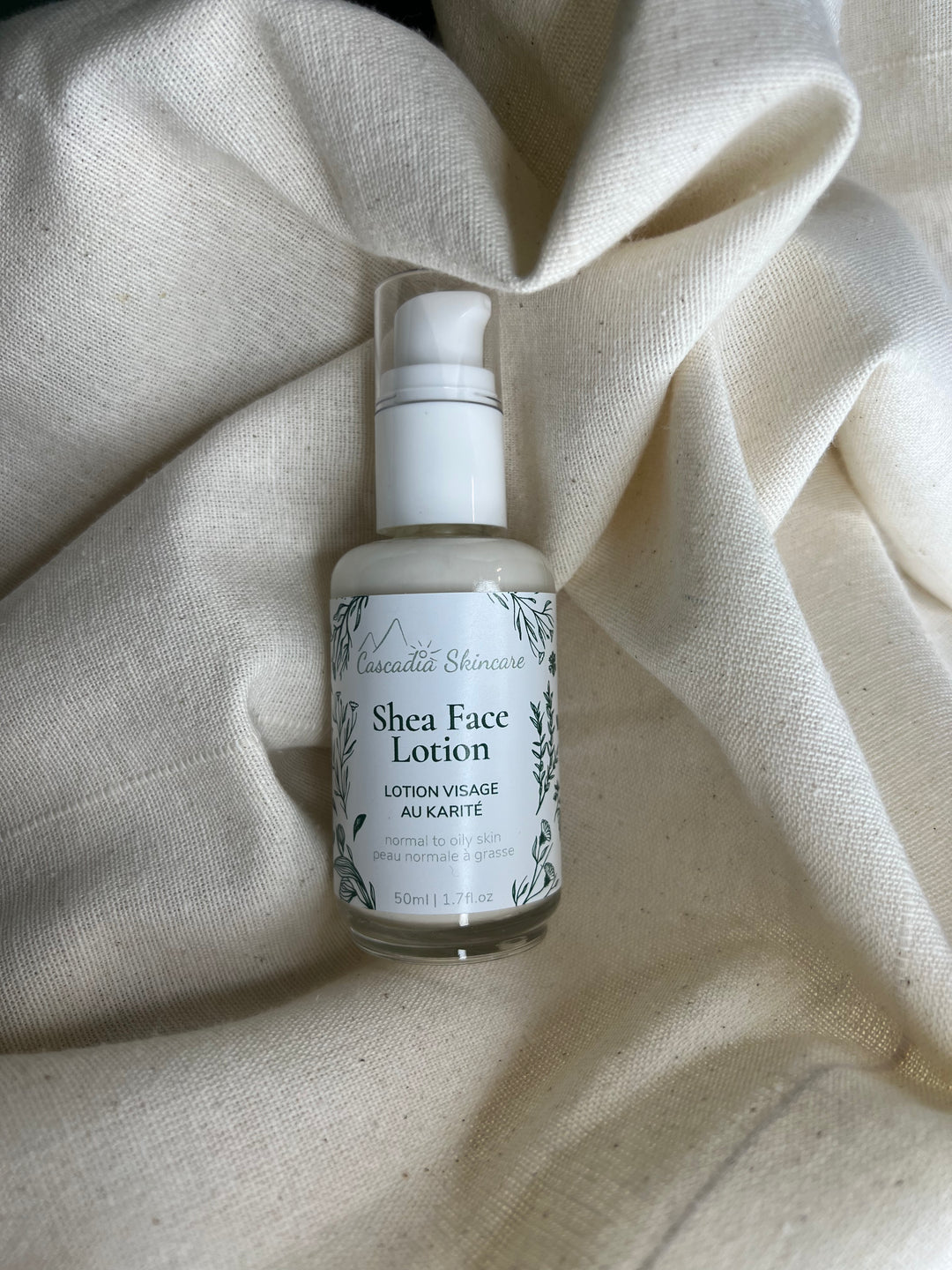 Shea face lotion bottle on a textured beige fabric background