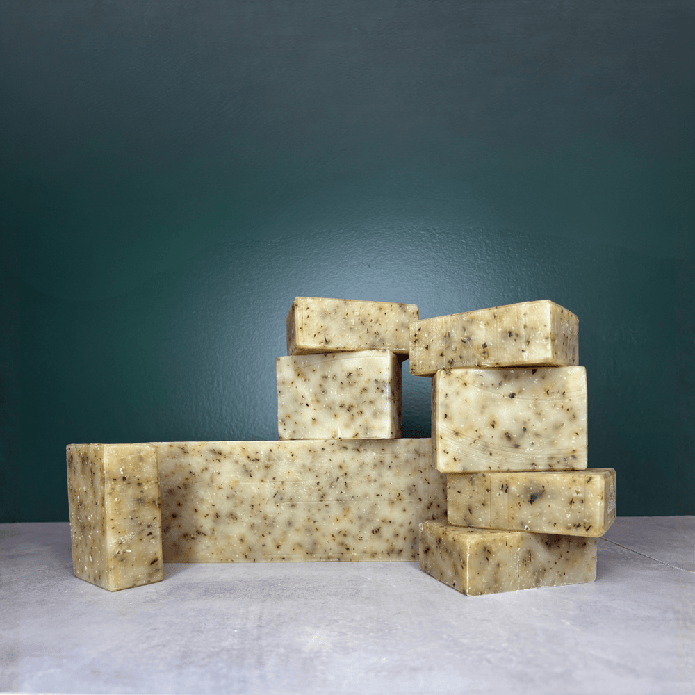 Peppermint & Tea Tree bars and bulk bar shown on a grey countertop and green background.