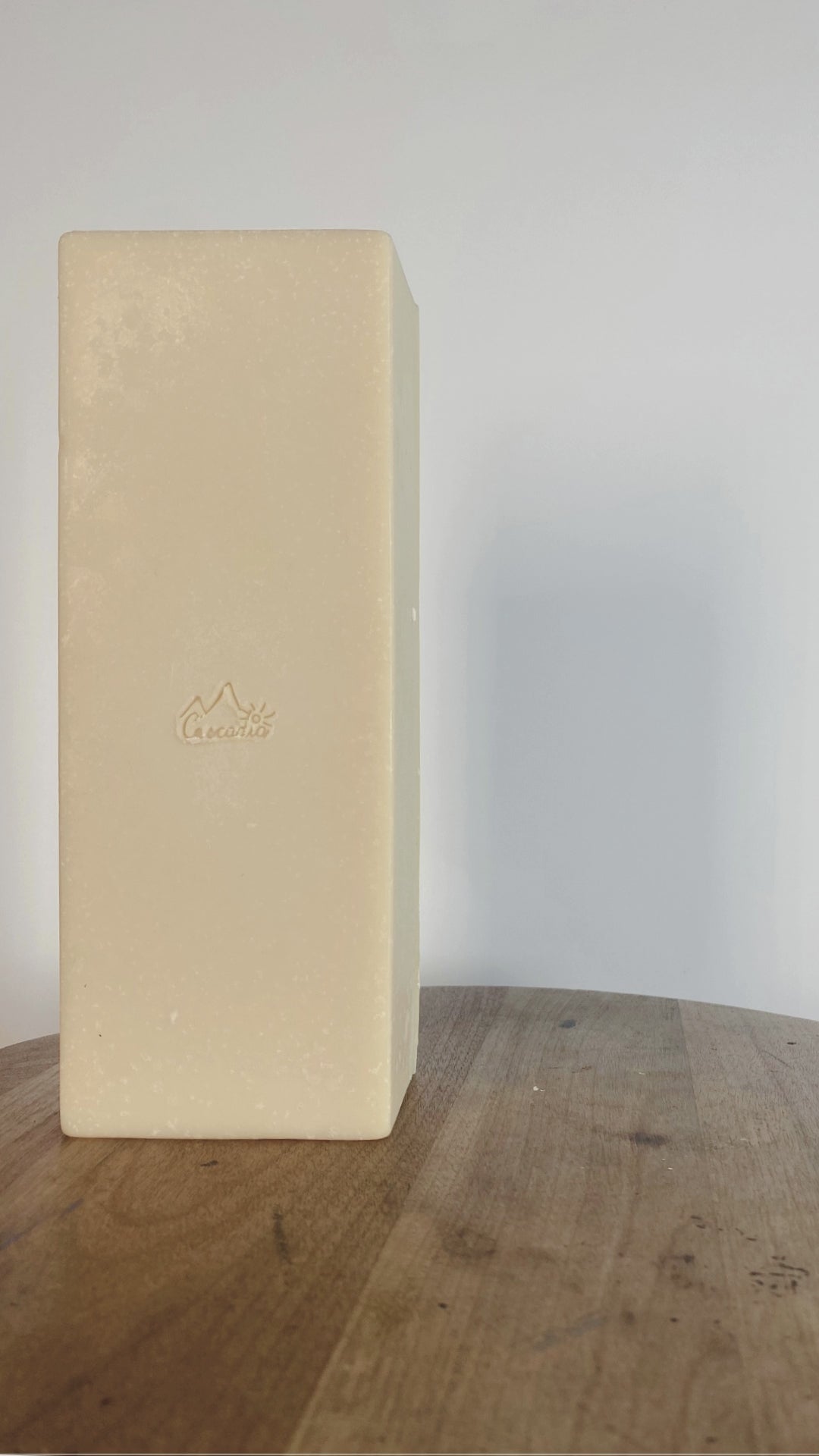 7 goat milk soap bars are stacked beside Cascadia's goat milk bulk bar to show that a bulk bar is equivalent to 7 regular soap bars